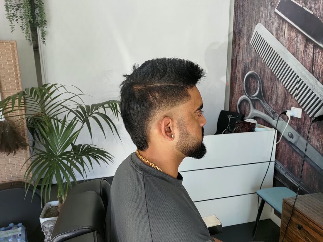 Swept-back quiff with a hard part and beard